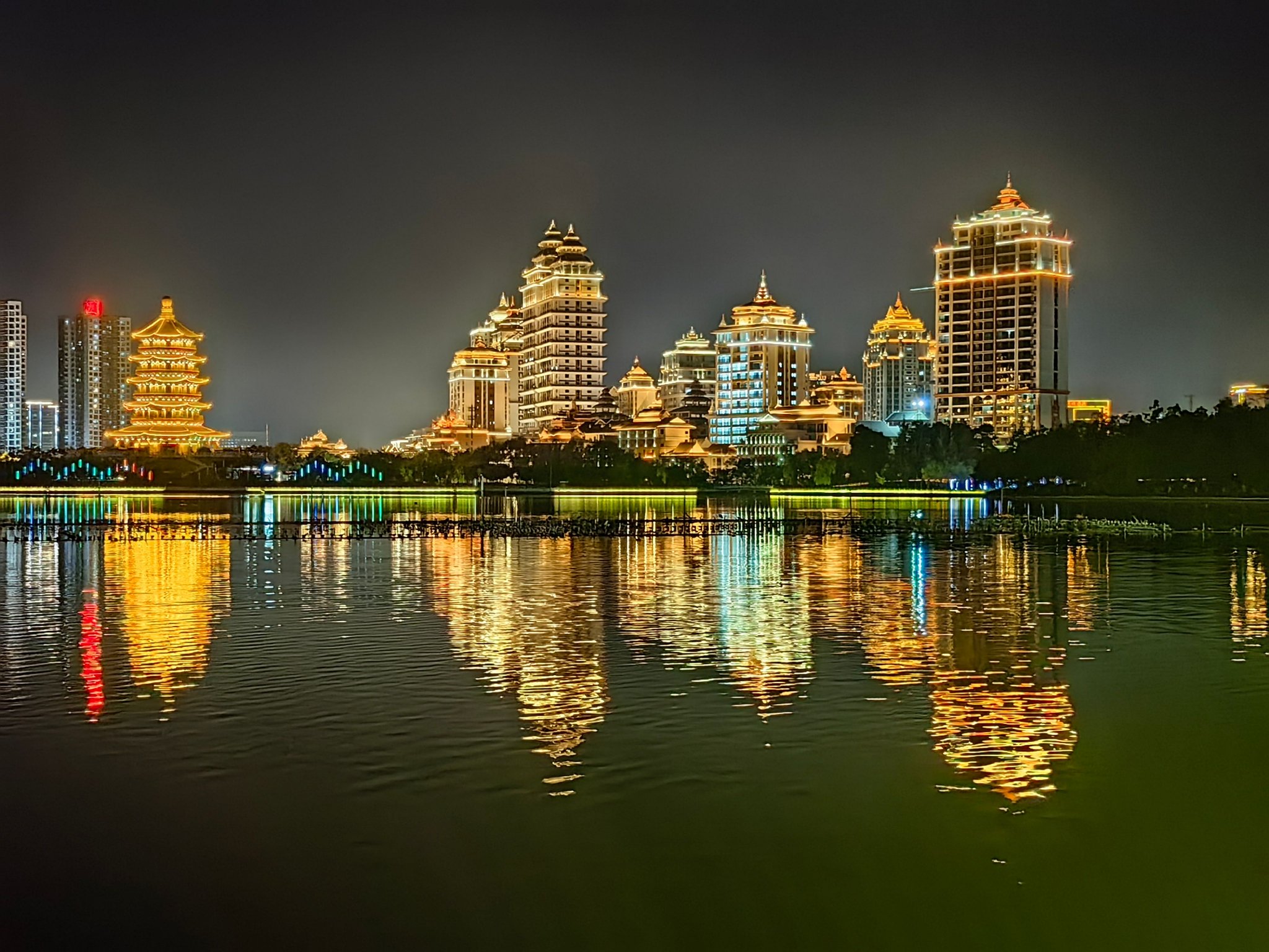 夜色下的临沧玉龙湖,灯光亮起,佤山凤城与锁水阁如梦如幻