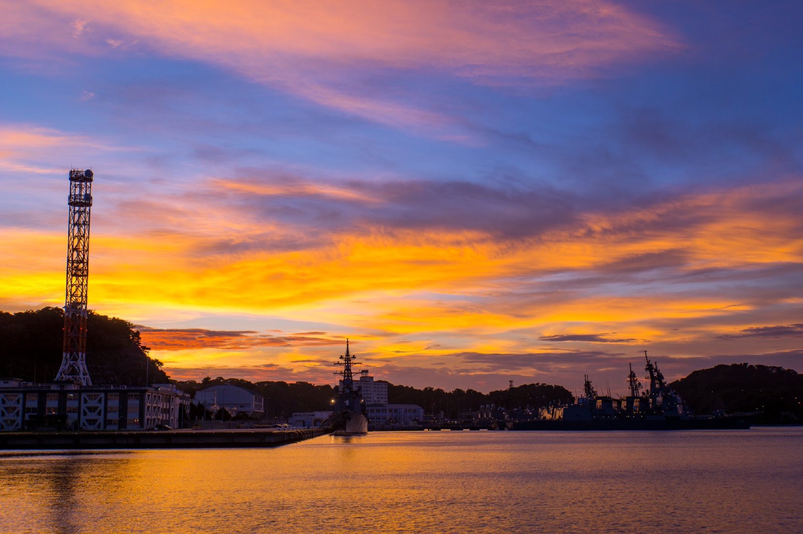 傍晚时分,红彤彤的晚霞与威武的战舰形成了一道醉人风景.
