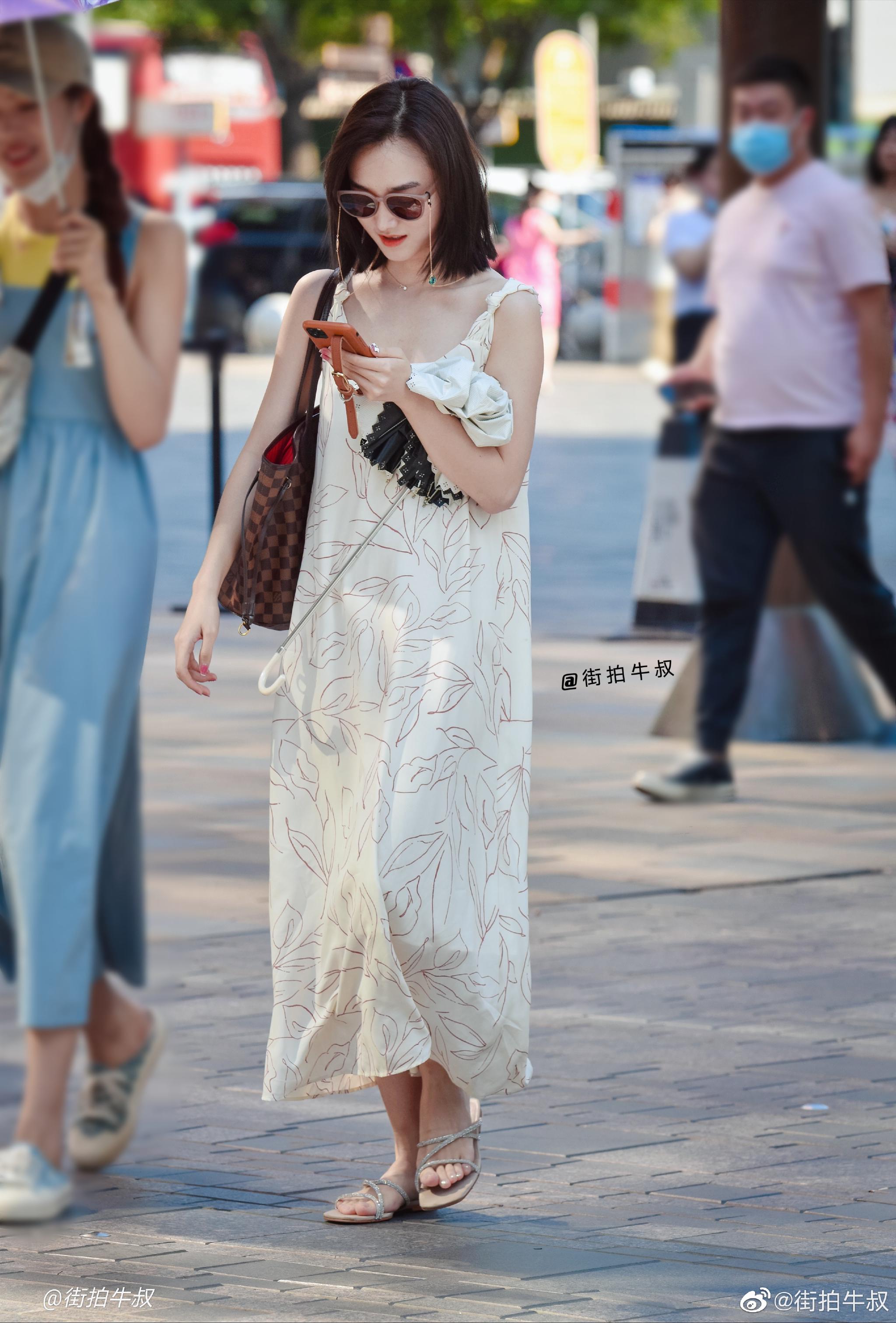 美女穿着可爱的印花吊带裙出街