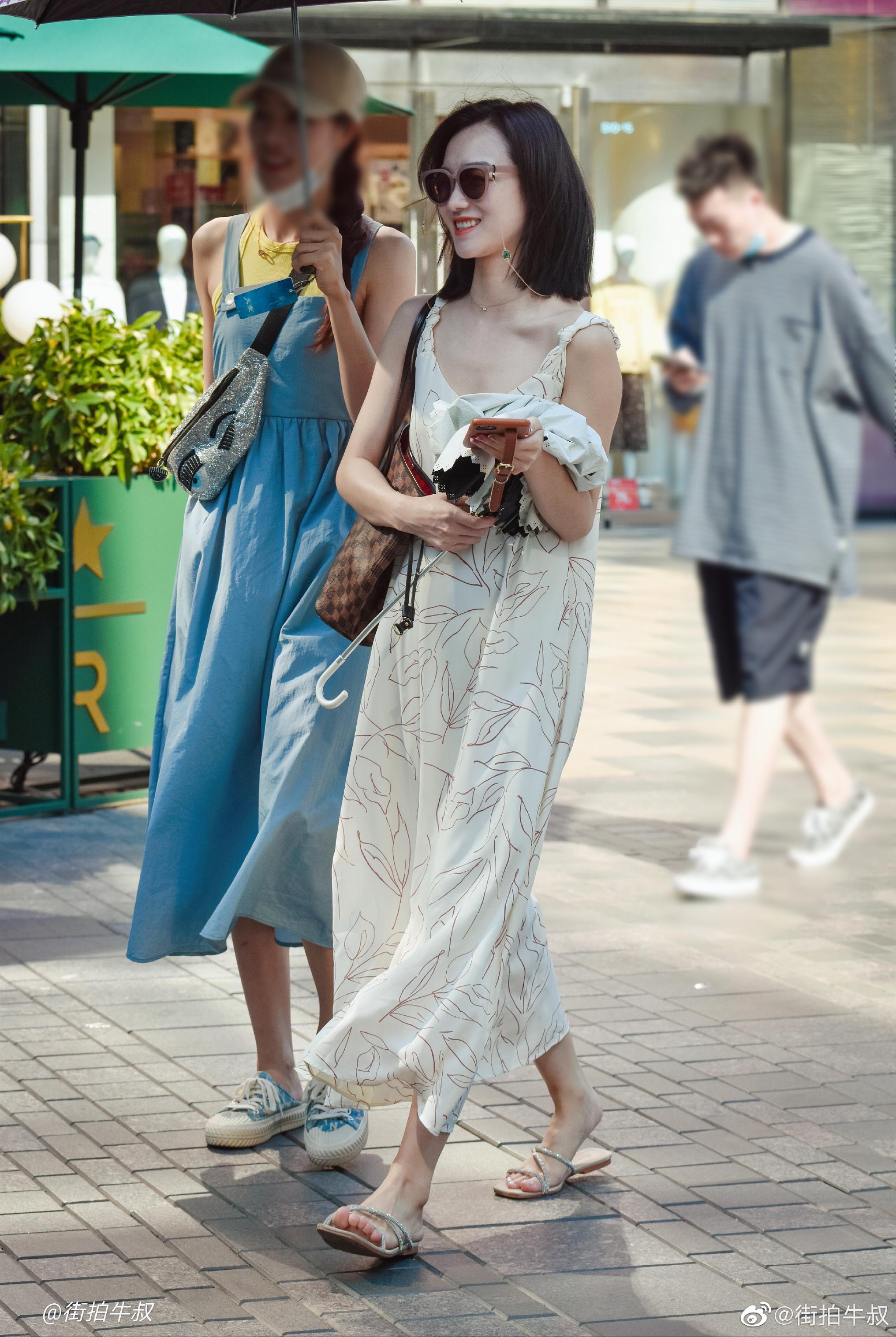 美女穿着可爱的印花吊带裙出街