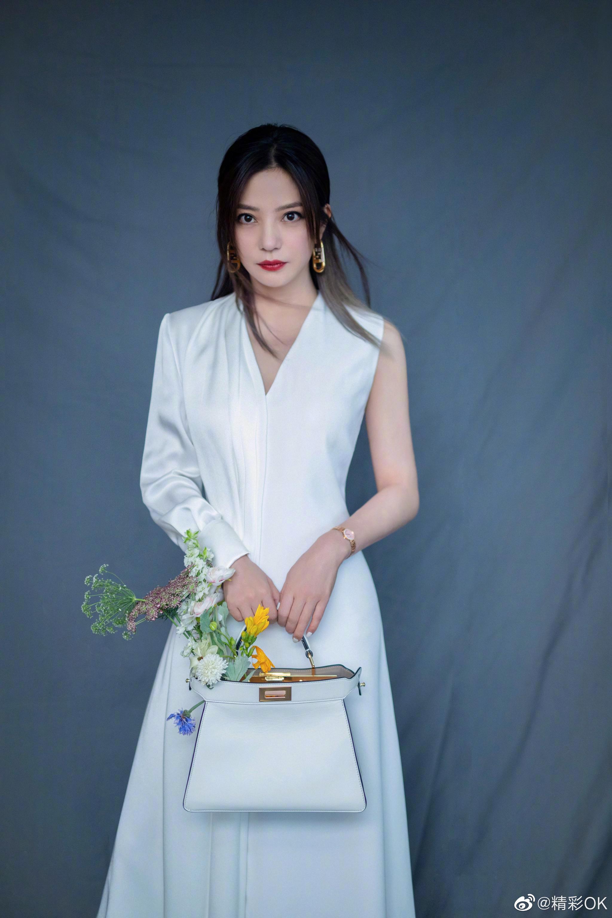 赵薇一身纯白拼接长裙复古红唇手持白色花朵优雅大方
