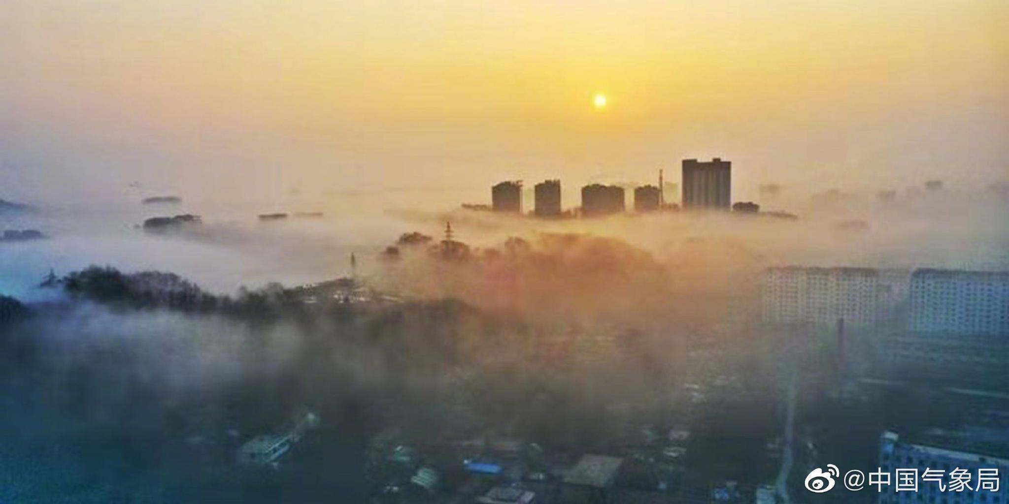 晨初,辽宁丹东大雾弥漫,萦绕城市楼宇之间,宛如仙境
