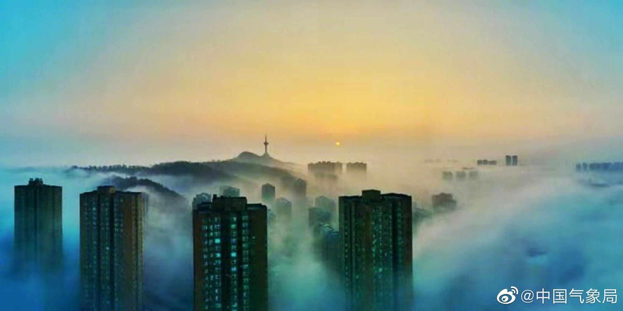 晨初,辽宁丹东大雾弥漫,萦绕城市楼宇之间,宛如仙境