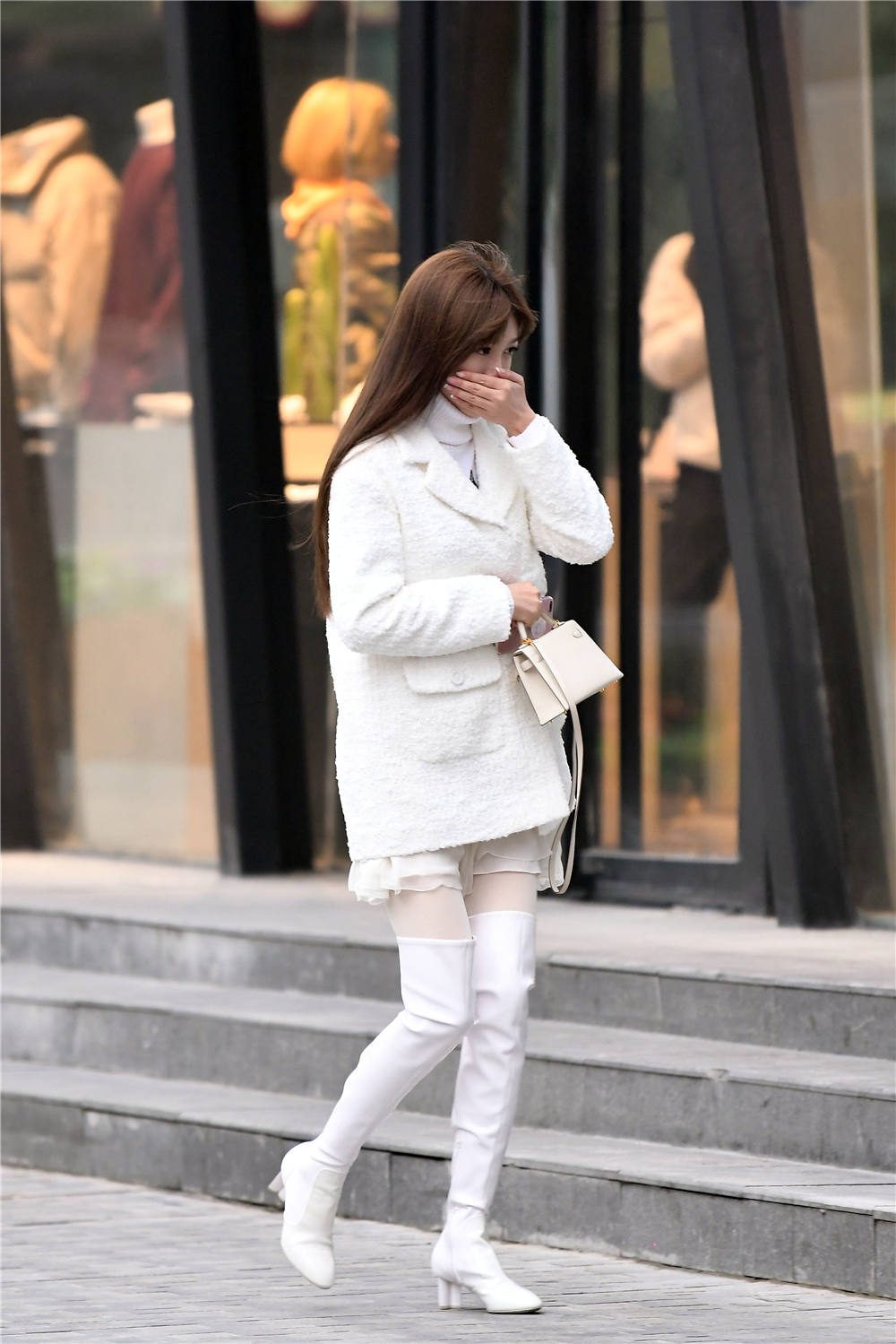 看一下这位美女的穿搭,选择白色的过膝长靴,靴筒稍微高一些的设计