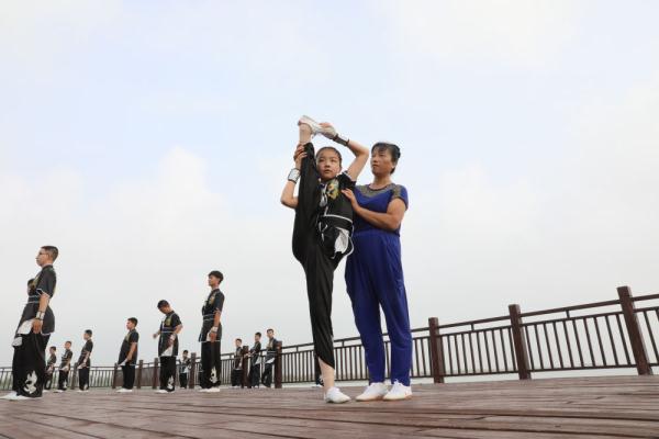7月17日,教练指导学生们在南宫湖畔练习"南宫开河少林散手通背门".