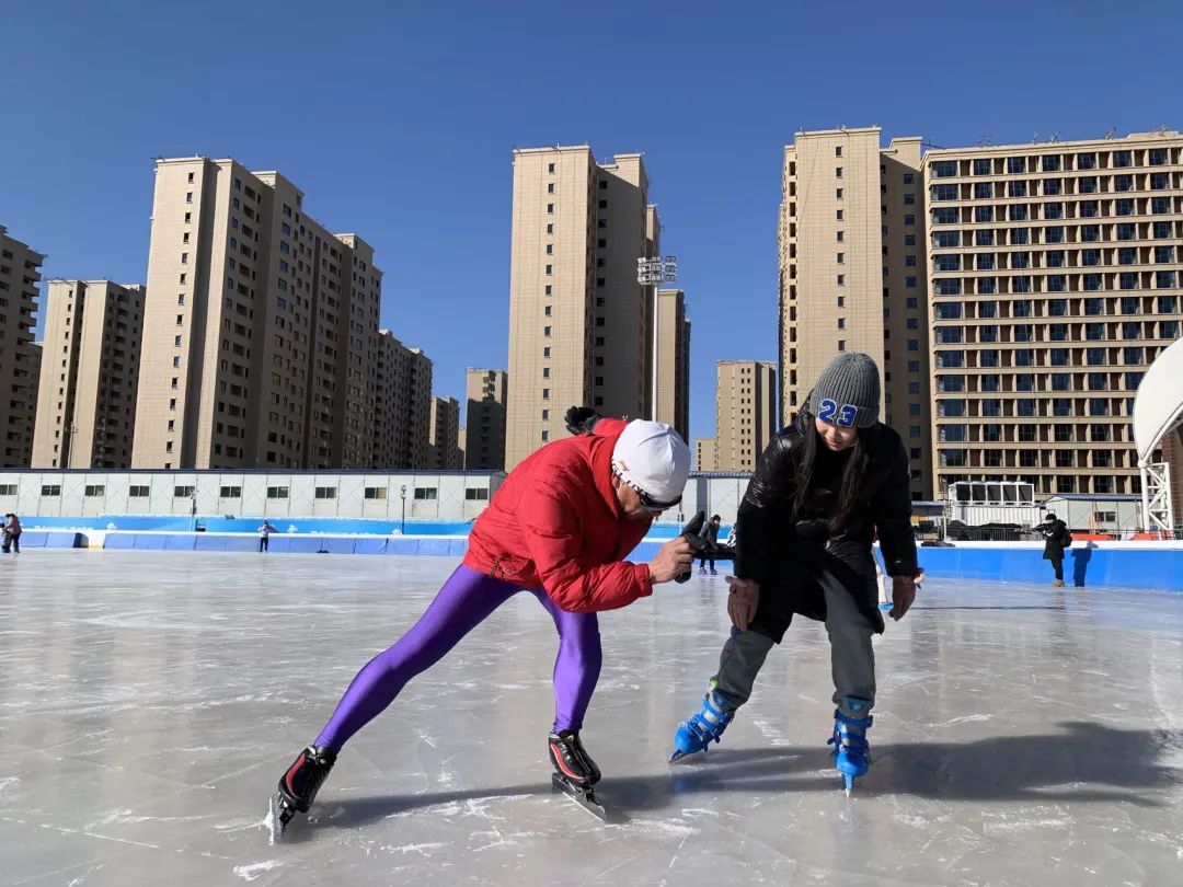 在家长的带领下,10岁的赫英华和7岁的赫英东在冰上滑得正欢.