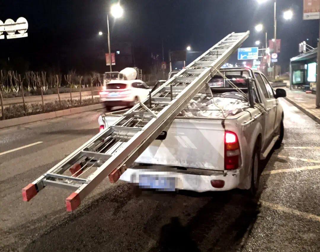 两块长度达七米左右的梯子就搭在货车上,车后还耷拉出去一两米,且就用