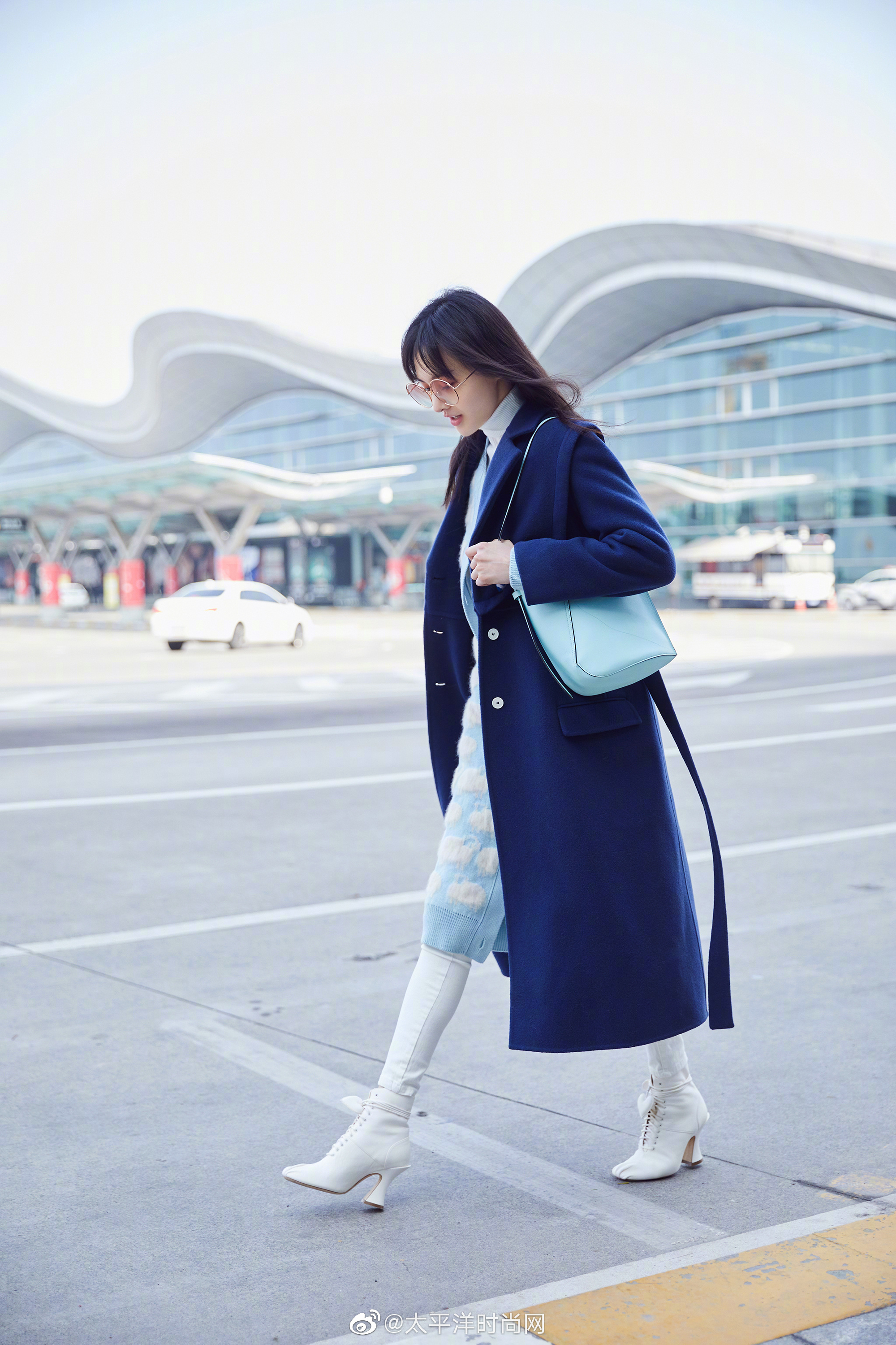 身着宝蓝色大衣内搭温暖的针织衫,搭配白色修身裤与同色低跟鞋