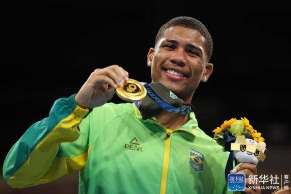 8月7日,获得冠军的巴西选手苏萨在颁奖仪式上展示金牌.