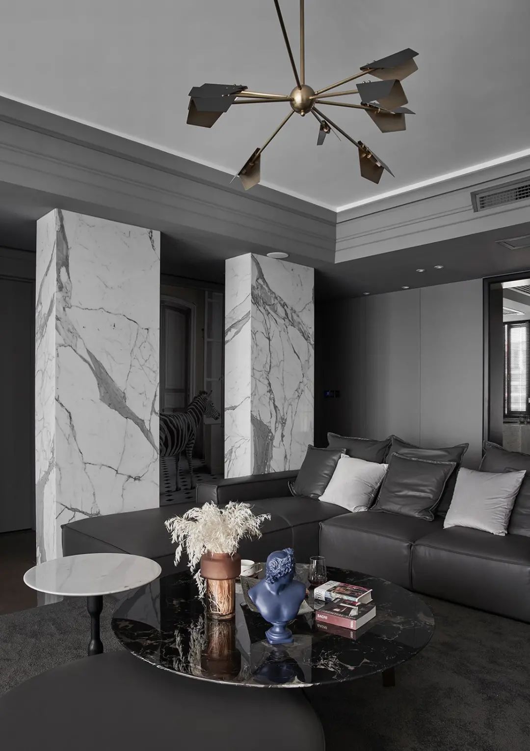 深灰色皮沙发与灰色地毯,墙面吊顶等硬装,也是以灰色的设计,过道旁