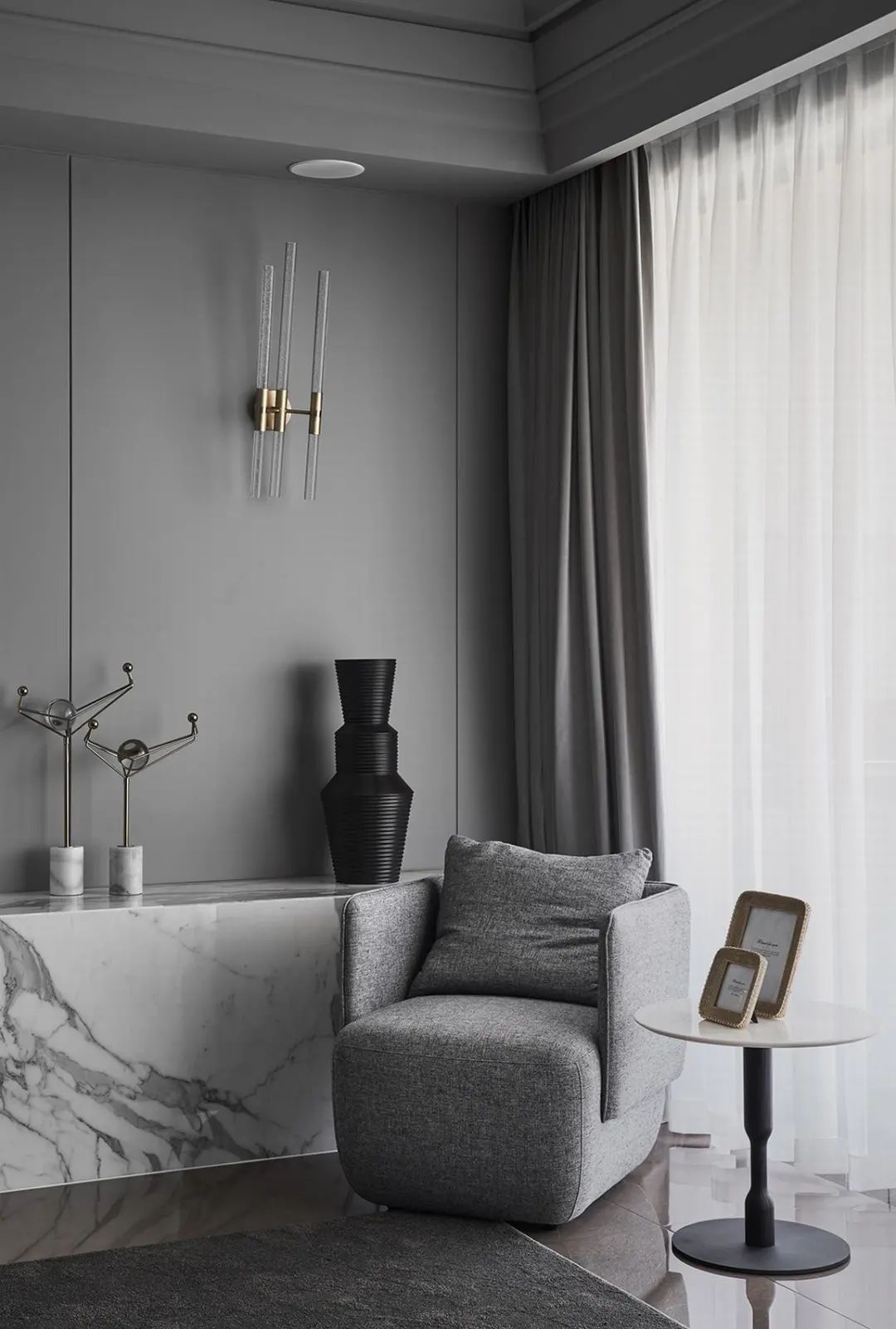 深灰色皮沙发与灰色地毯,墙面吊顶等硬装,也是以灰色的设计,过道旁