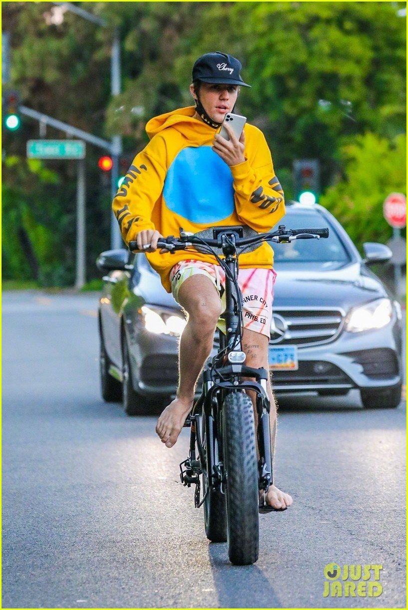 的贾斯汀·比伯( justin bieber)在比佛利山庄边骑自行车边打电话被拍