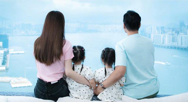 两人中间坐着双胞胎女儿,左边是像妈妈的妹妹lyvia,右边是像爸爸的