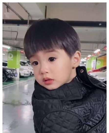 姜潮抱娃现身停车场被拍两岁丹尼尔直怼镜头眼睛自带美瞳特效