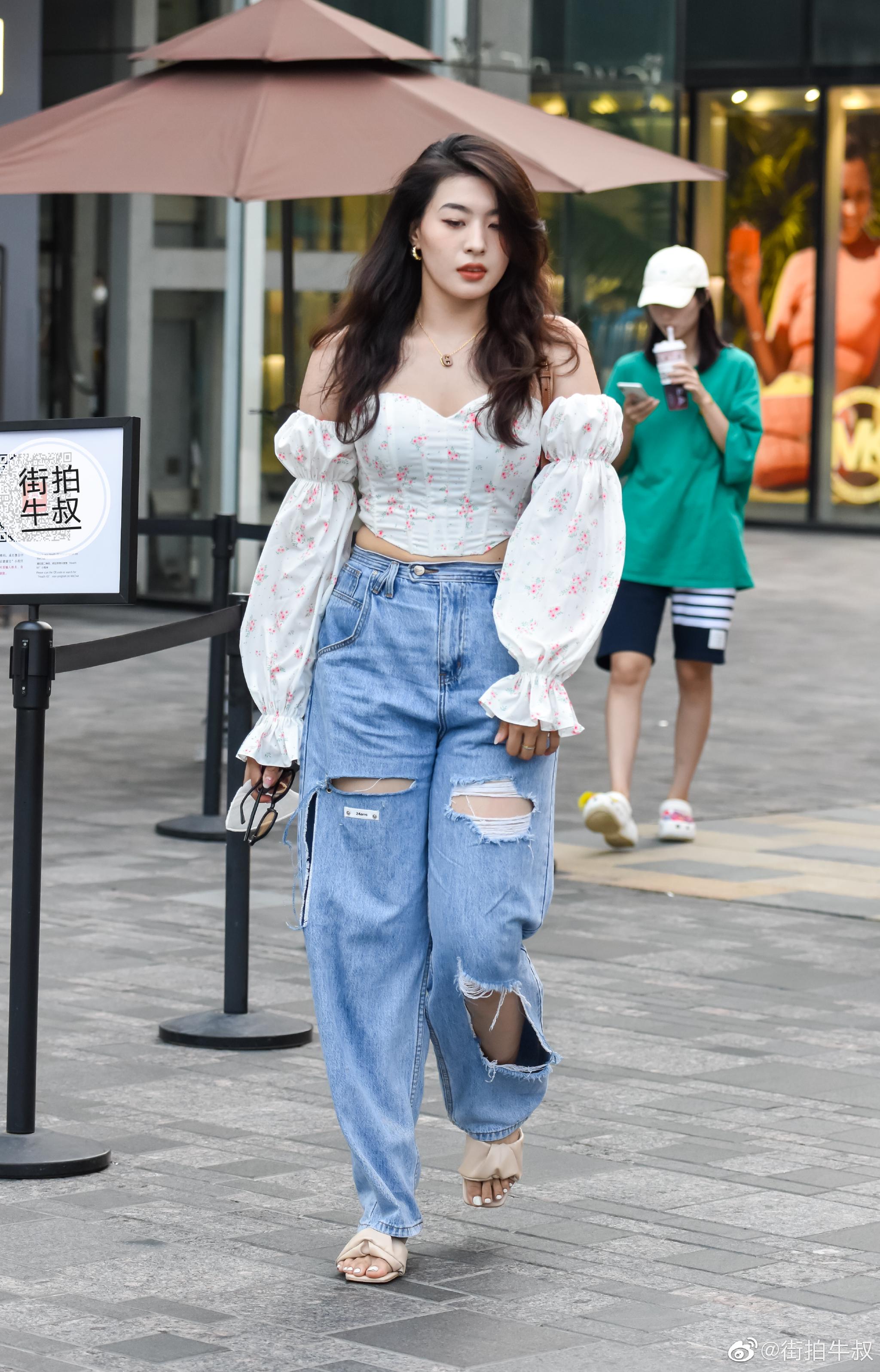 美女穿着一字肩泡泡袖碎花衬衫出街