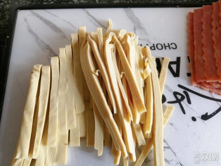 把千张分为十小份,依次放培根上卷起来用牙签固定码在垫锡纸的烤盘上