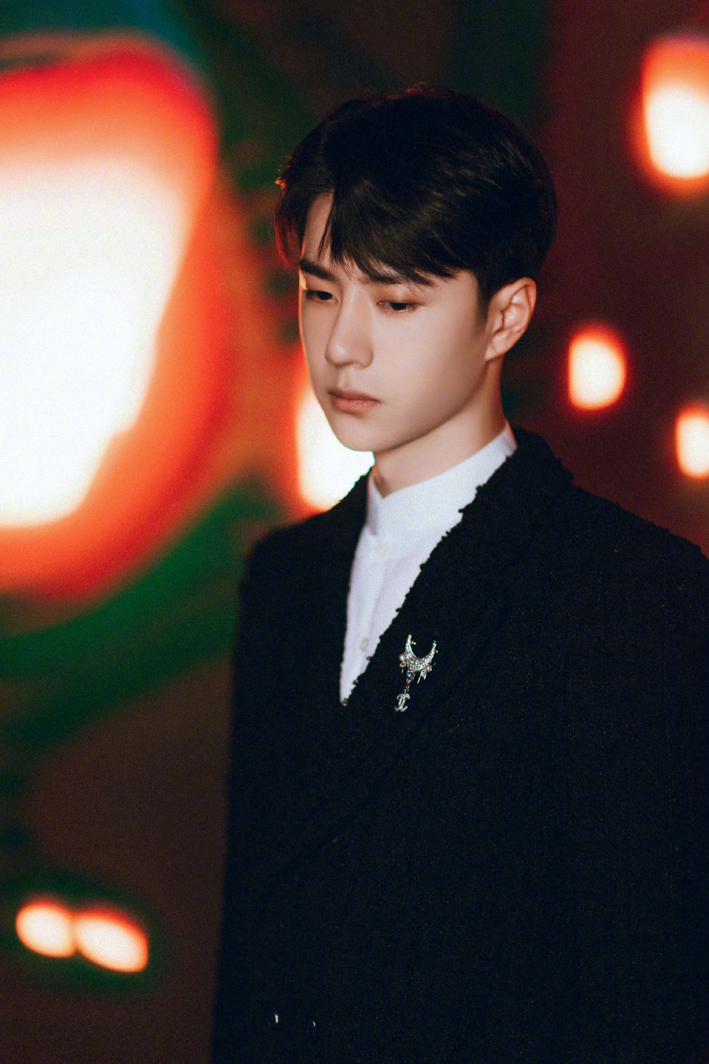 王一博身着优雅的黑色软呢外套,别一枚月亮钻石胸针点亮细节