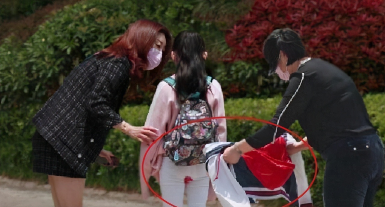 "阿姨脱下了自己的衣服,帮女孩挡住了裤子.