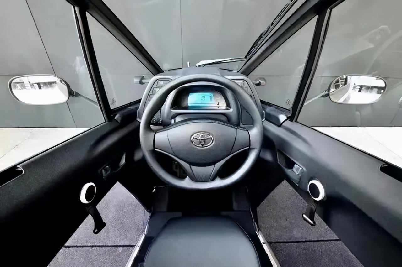 相比于独特的外观设计,丰田i-road的内饰风格相对比较简单,蓝色背光的