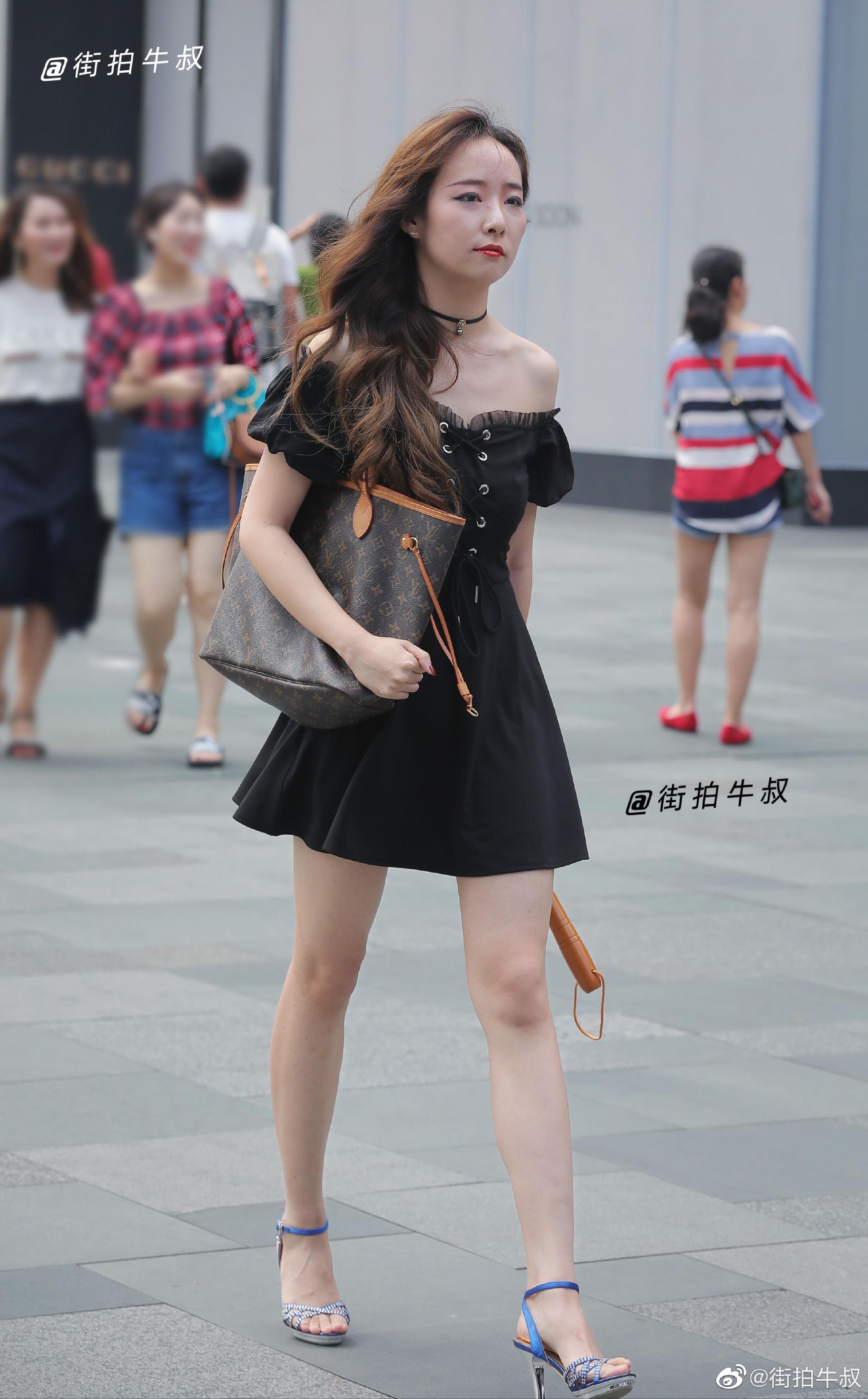 美女穿着洋气的露肩绑带连衣裙出街