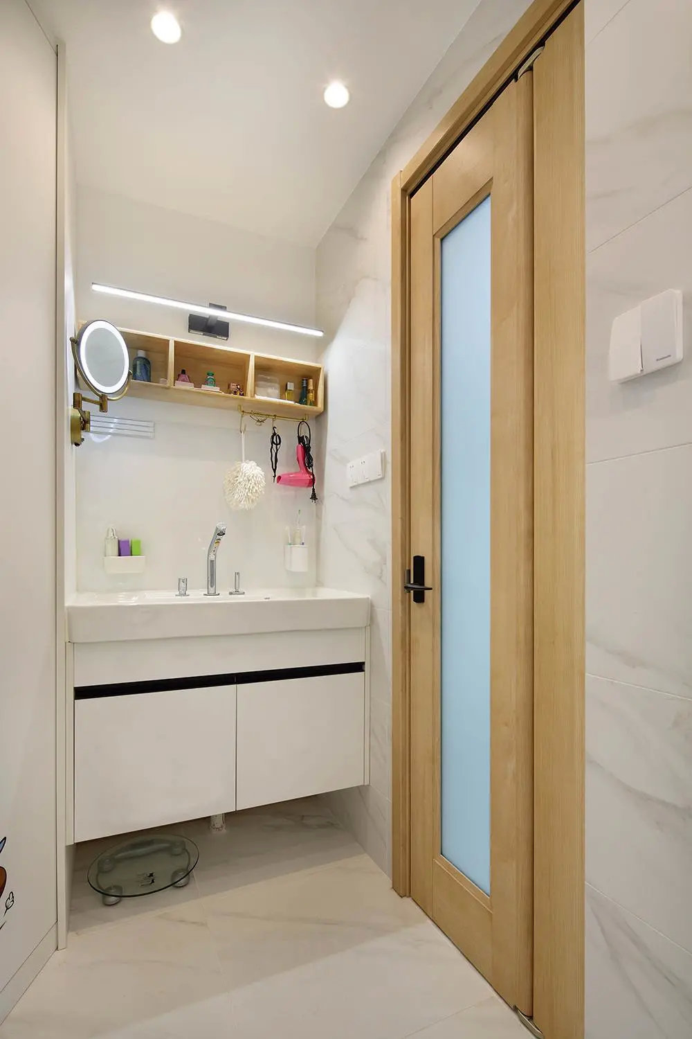 化妆柜顶部安装了收纳架,中间同样用到一块珐琅板墙面.