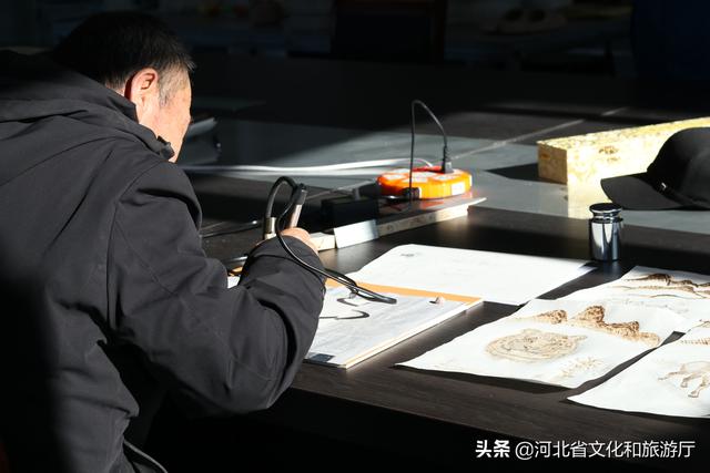 师傅正在牛皮上作画.刘郁雯 摄《张库大道——草原丝路》牛皮烙画.