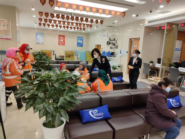 渤海银行长春分行的员工邀请在外辛苦劳作的环卫工人进屋歇歇脚,暖暖