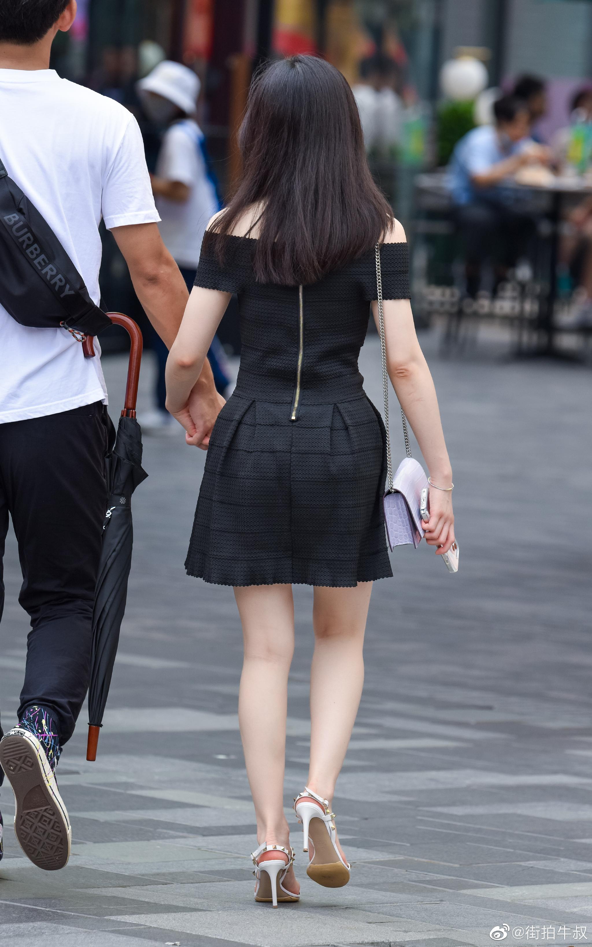 美女穿着漂亮的黑色花苞裙出街