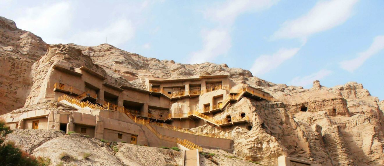 克孜尔石窟位于新疆拜城盆地南端,雀儿塔格山北麓的木扎特河东岸断崖