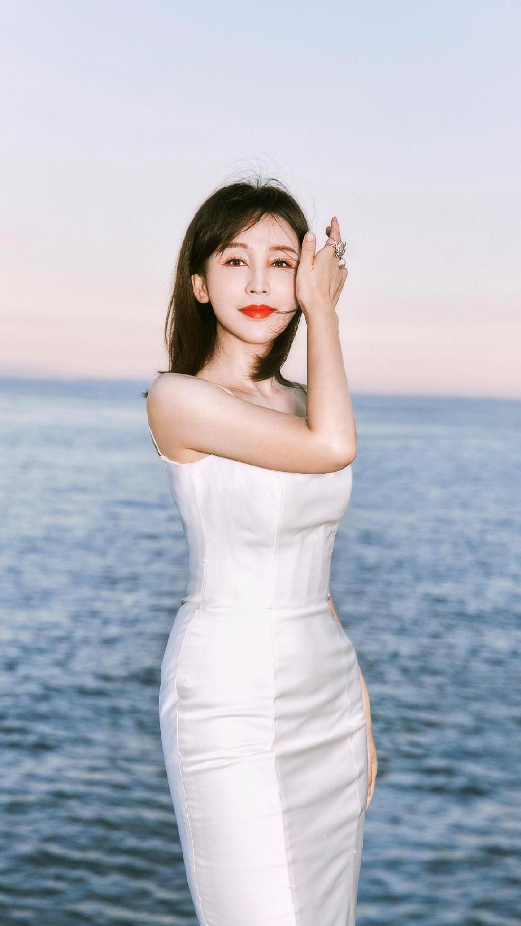 在昨日最新公布的活动前海边写真当中,岳丽娜身着纯白高定裹臀晚礼,在