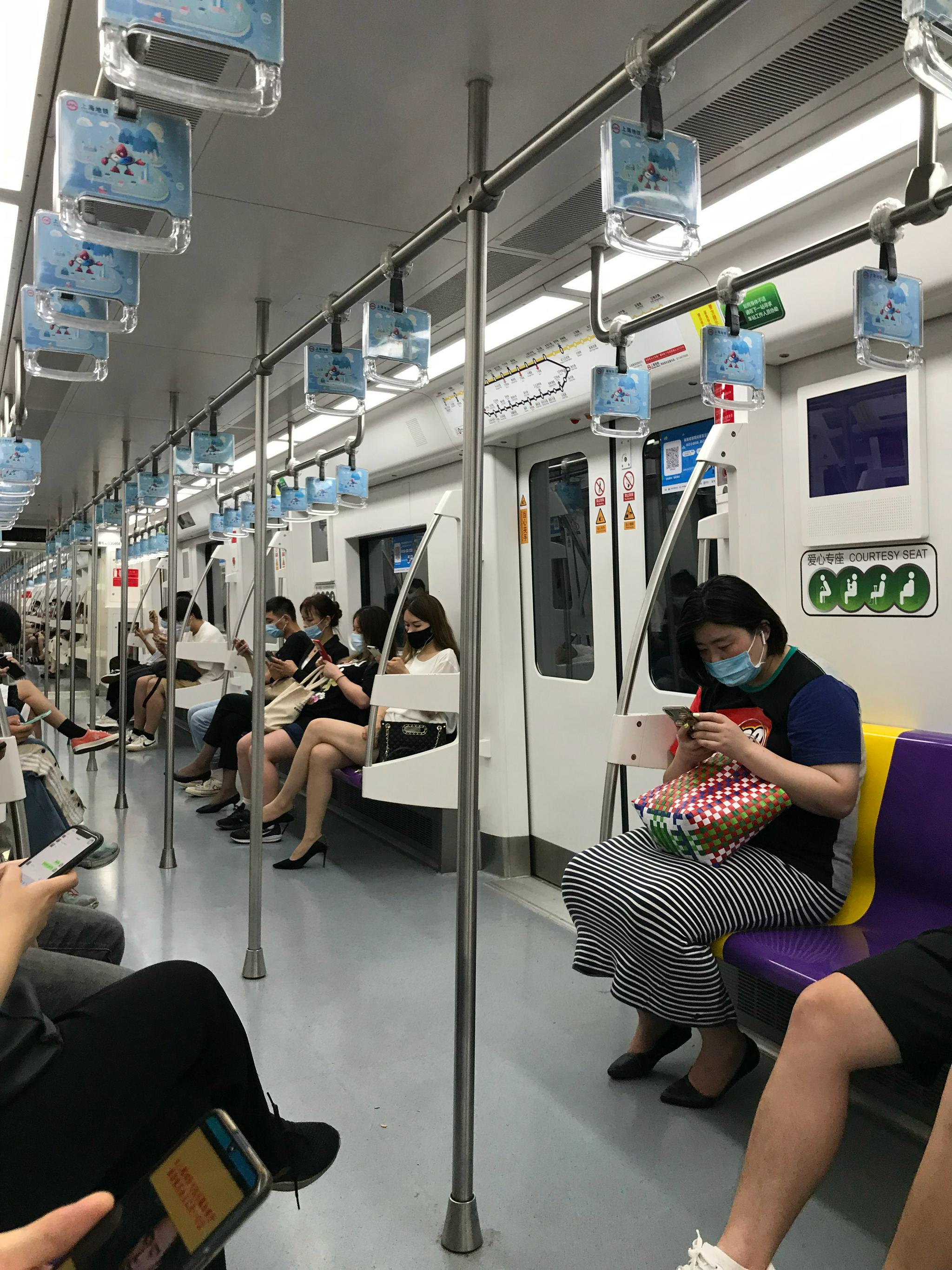 上海夜晚的地铁,人人戴上口罩,个个拿着手机,车厢里很安静