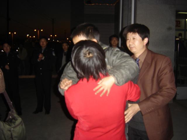 陈书根大队长把小孩交给母亲高永明书记(右1),我(右2),顾龙秀局长(右3