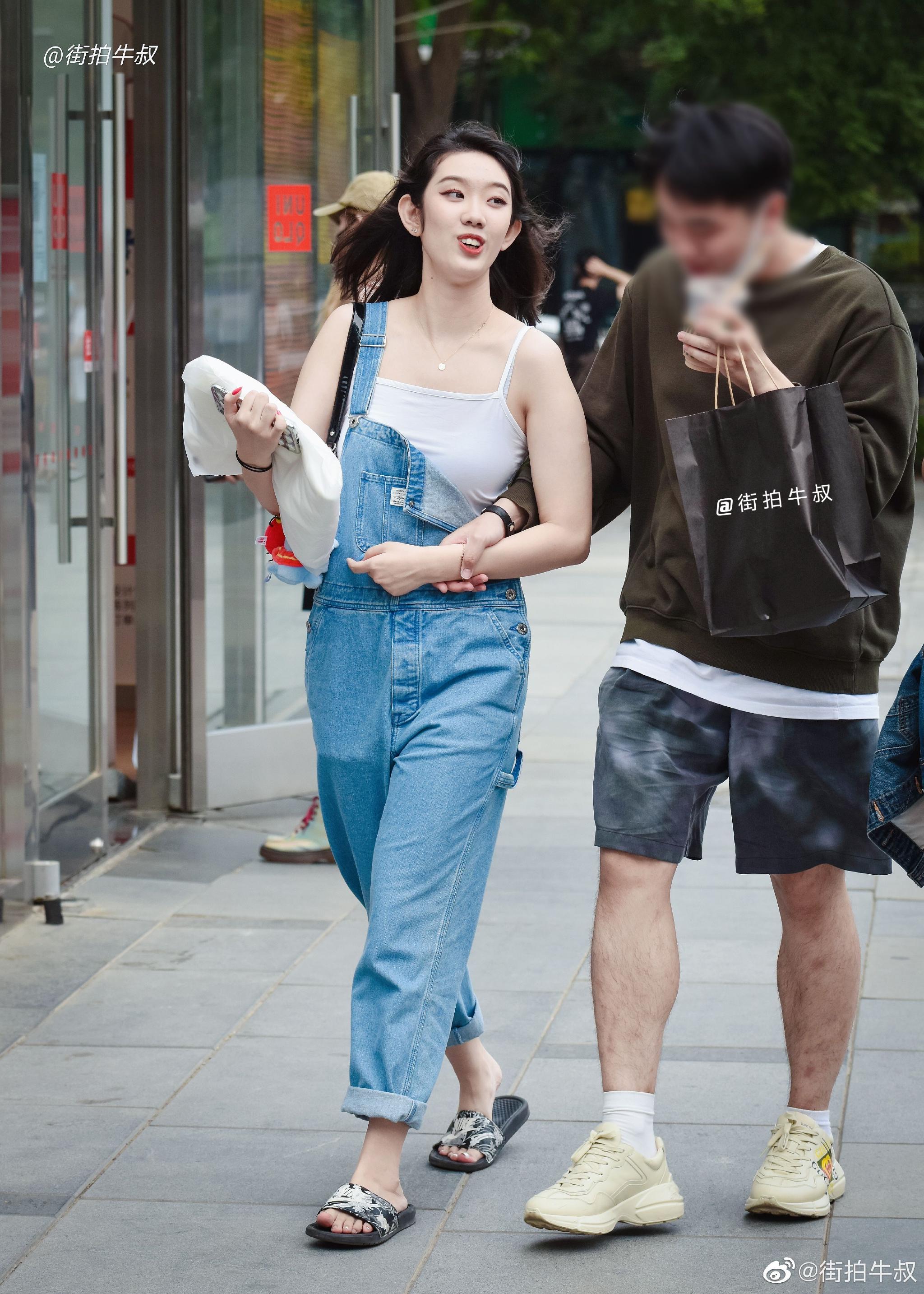 姑娘穿着可爱的牛仔背带裤出街