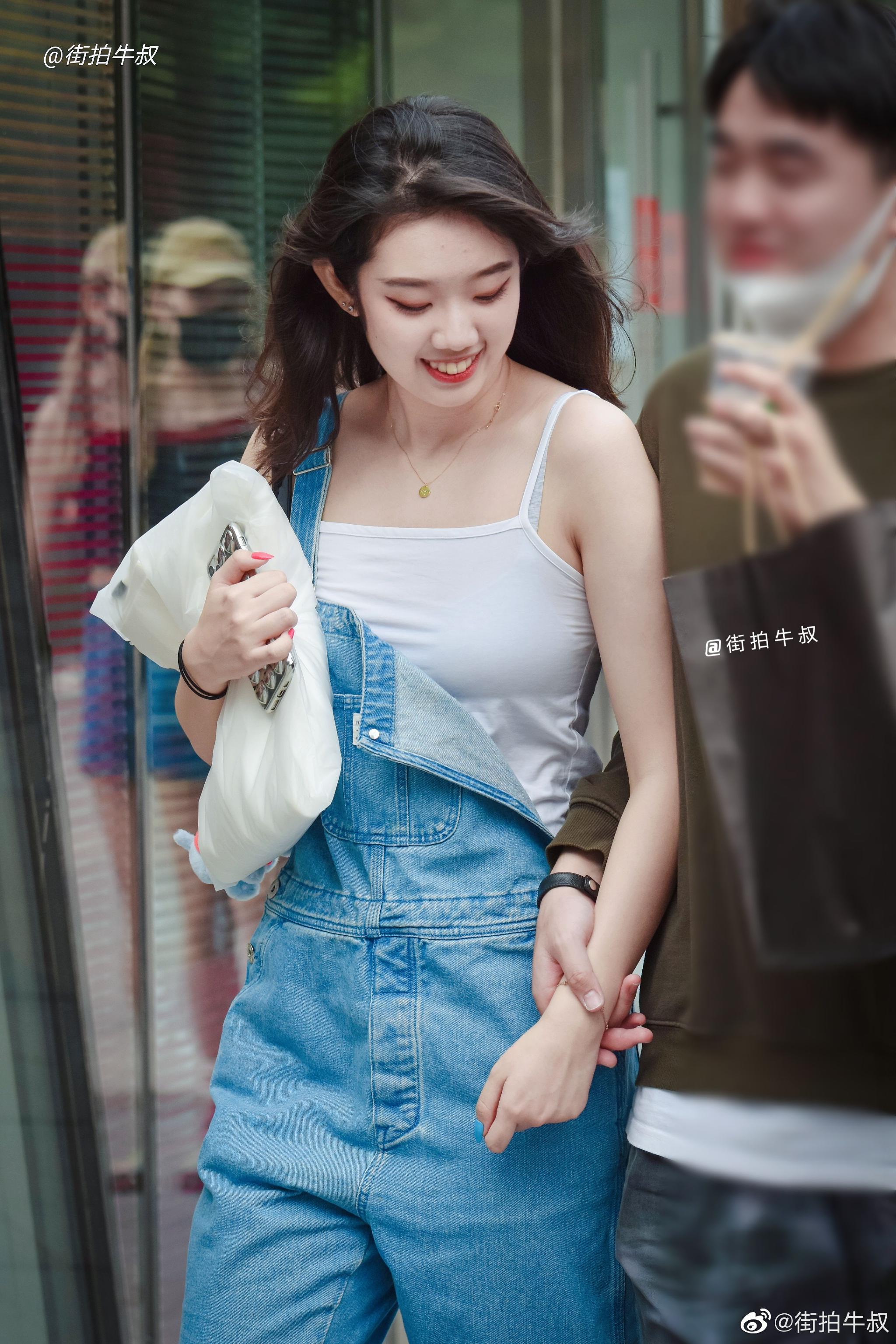 姑娘穿着可爱的牛仔背带裤出街