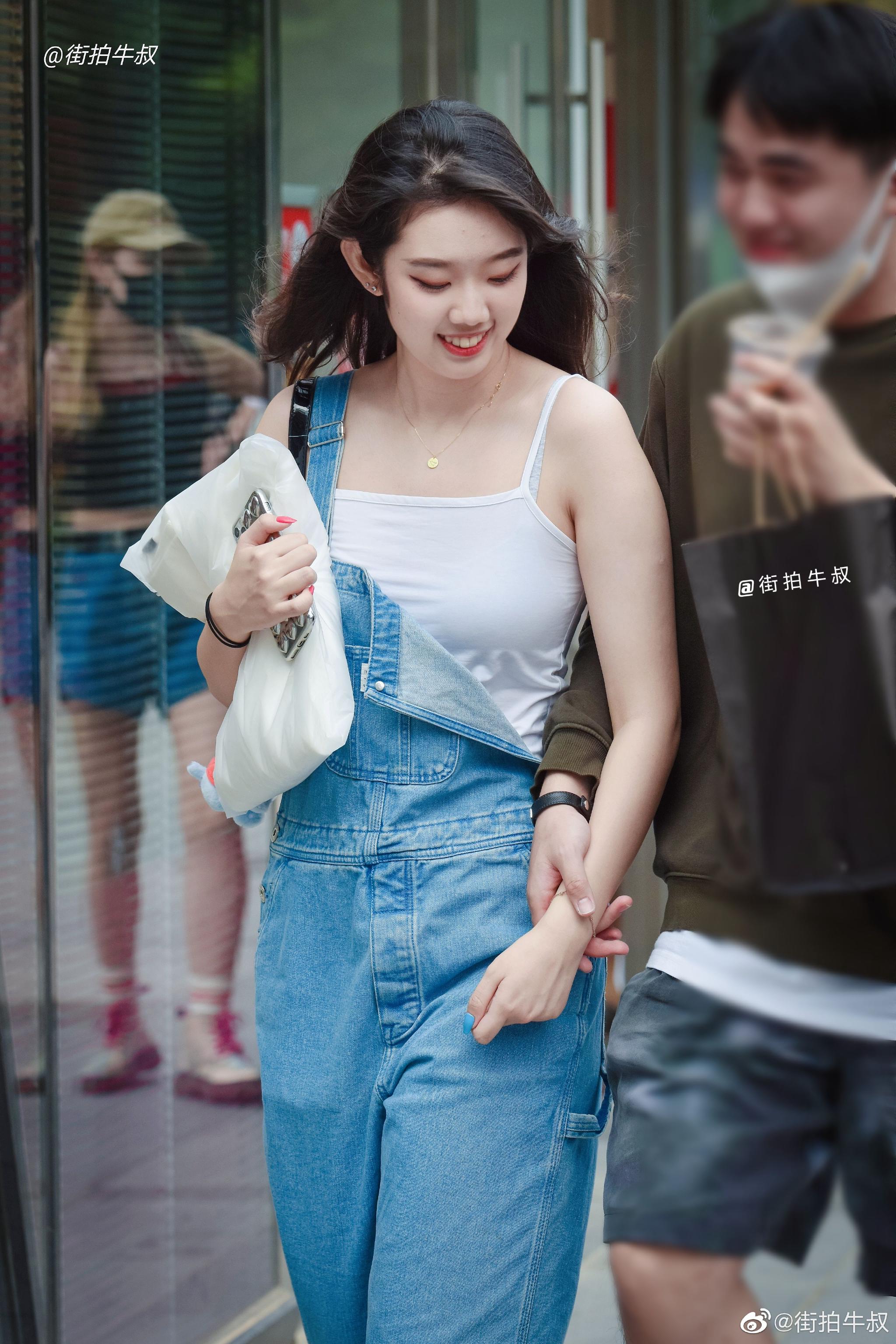 姑娘穿着可爱的牛仔背带裤出街