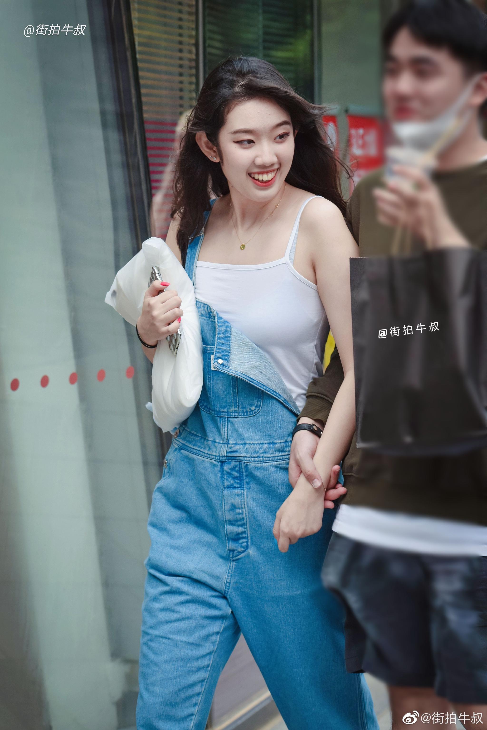 姑娘穿着可爱的牛仔背带裤出街