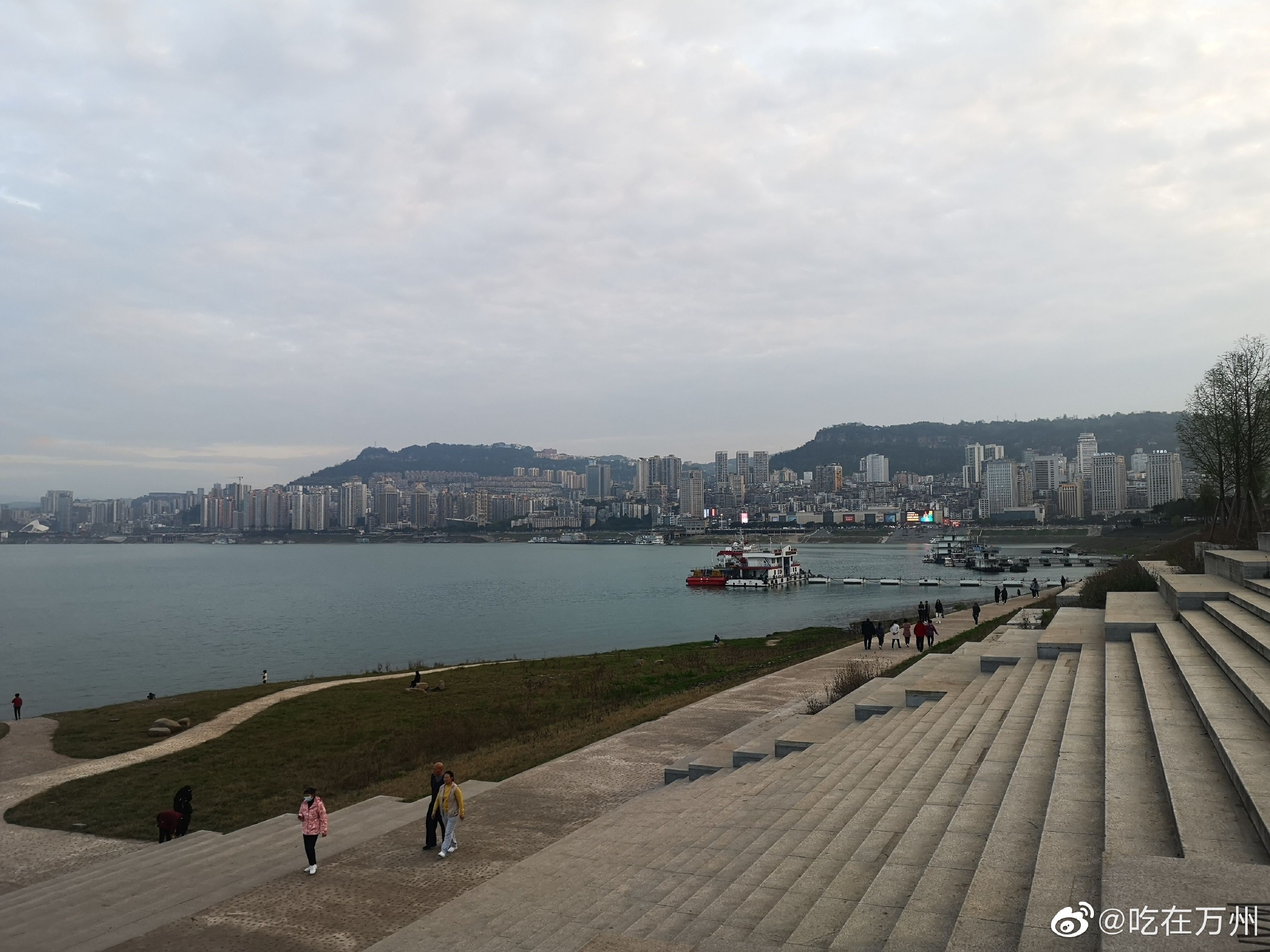 万州一江碧水，三三两两的行人江边漫步，水草也开始逐渐泛绿……__财经头条
