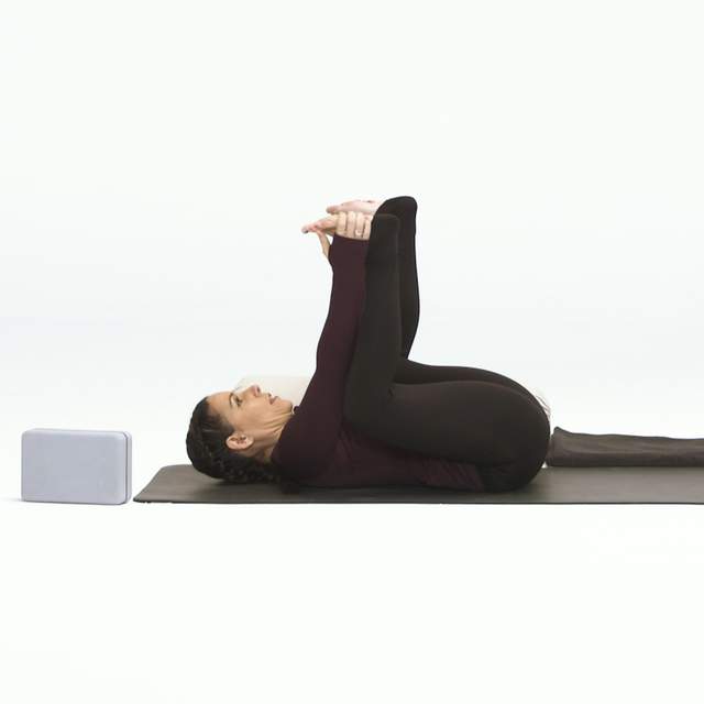 上半身平躺在瑜伽垫上,双膝弯曲成90度,大腿贴在腹部,两手伸直向上,勾