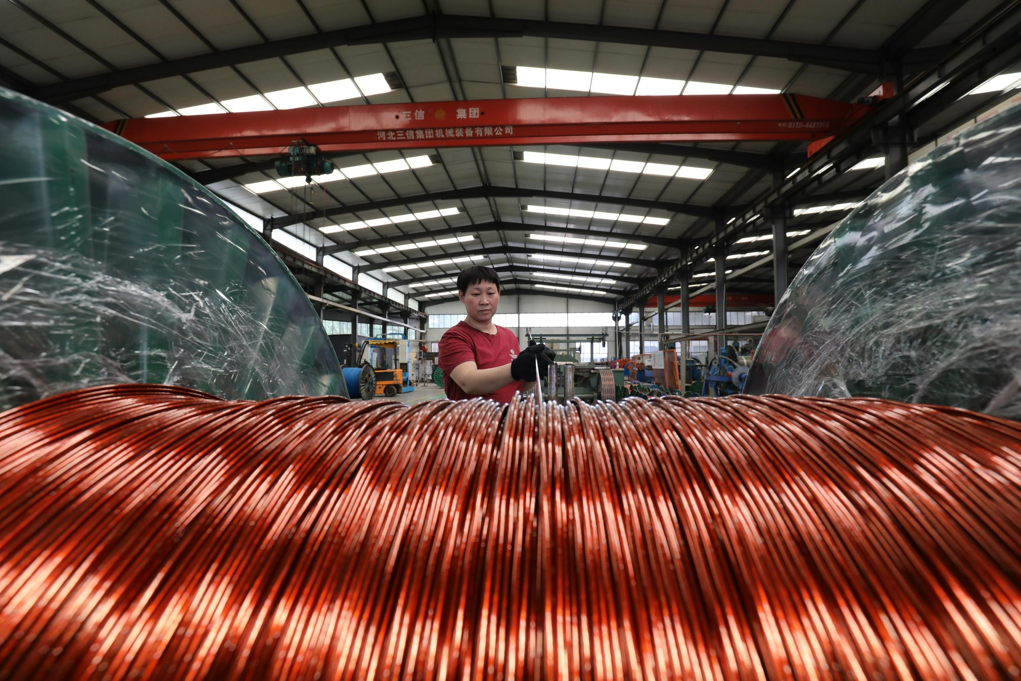 7月15日,河北省河间市一家电线电缆生产企业的工人在车间生产线上工作