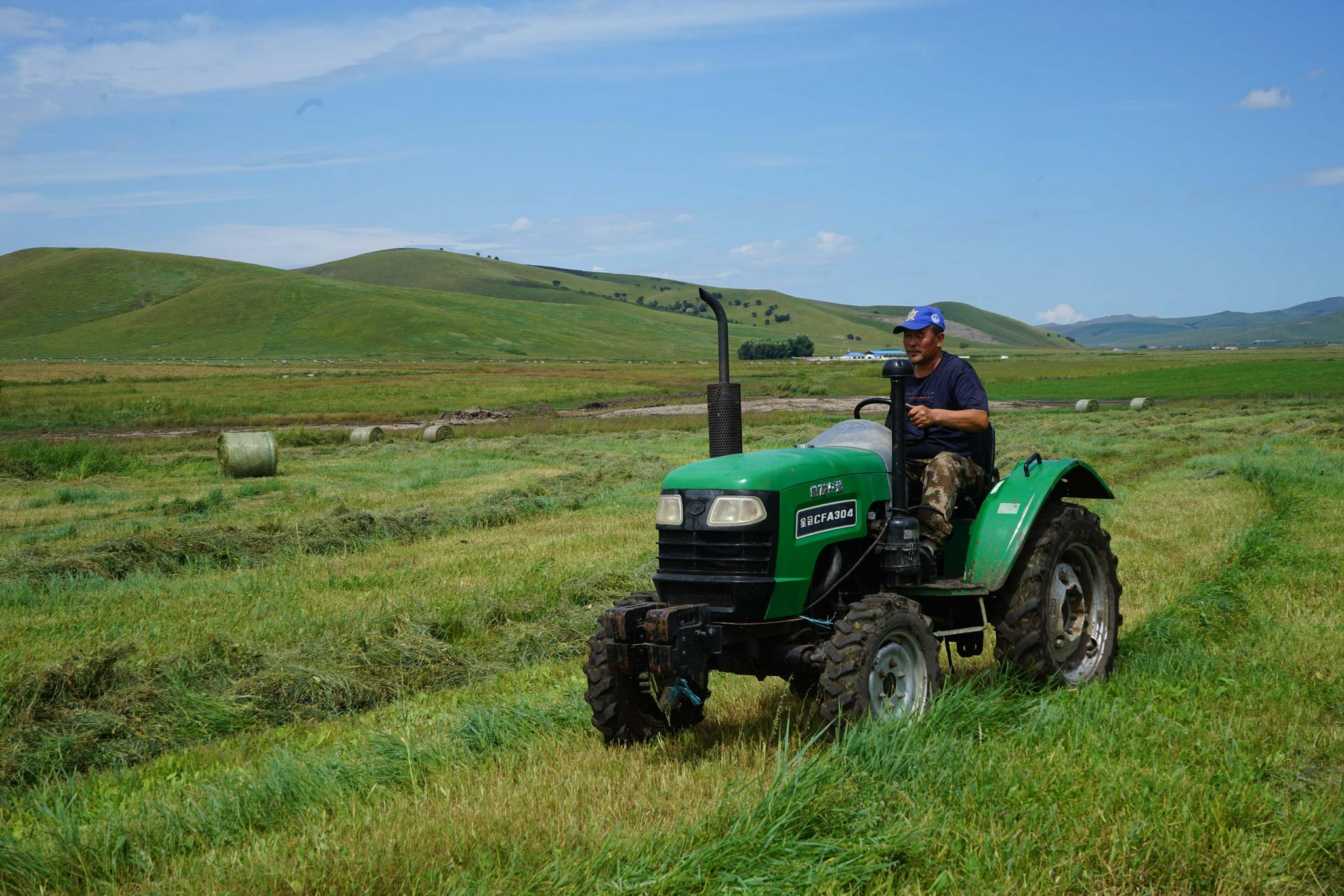 8月22日,牧民在乌兰毛都草原上驾驶拖拉机准备参与打草作业.
