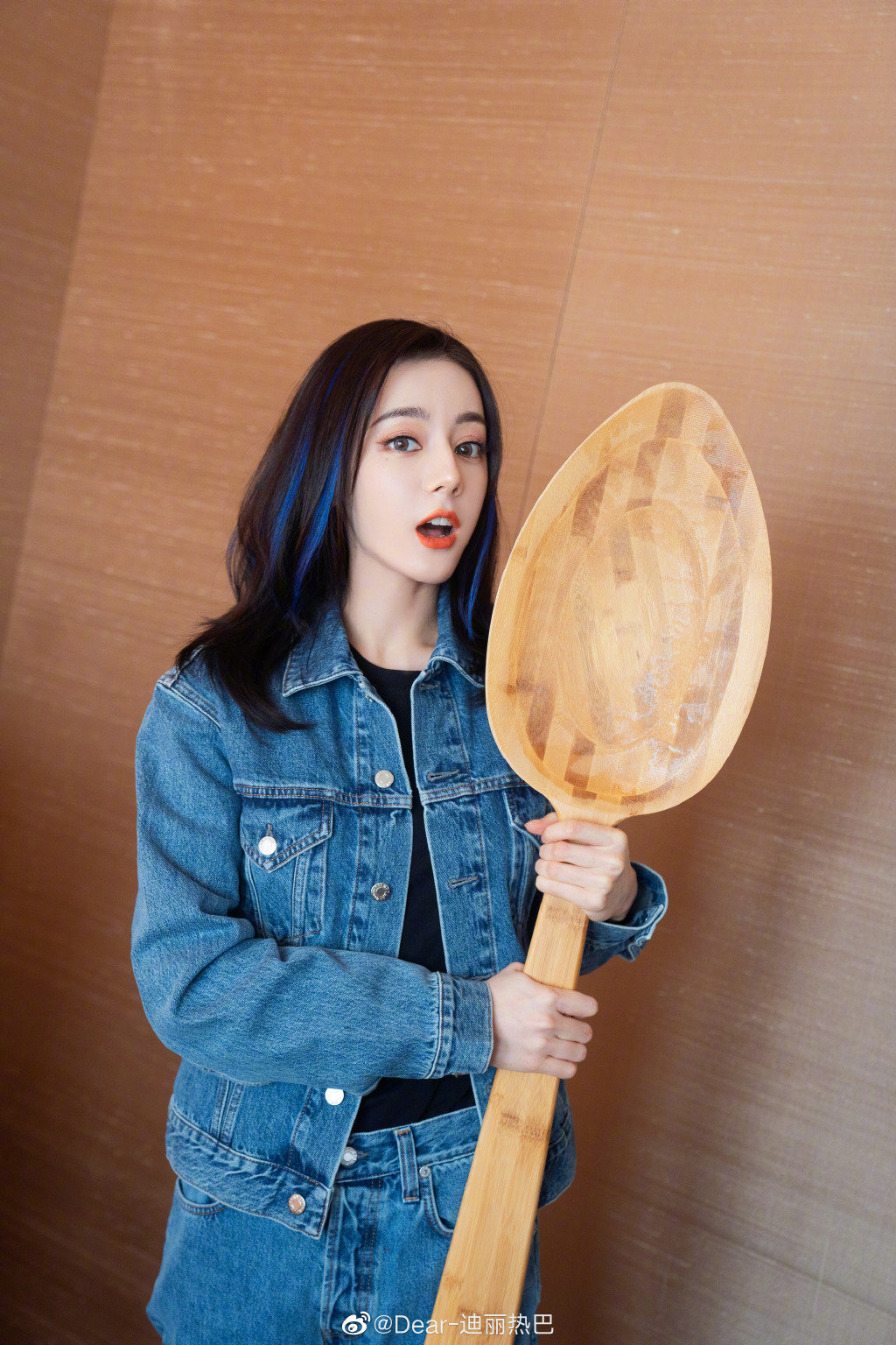 迪丽热巴一身牛仔衣搭配蓝色挑染发型手拿大勺表情生动可爱