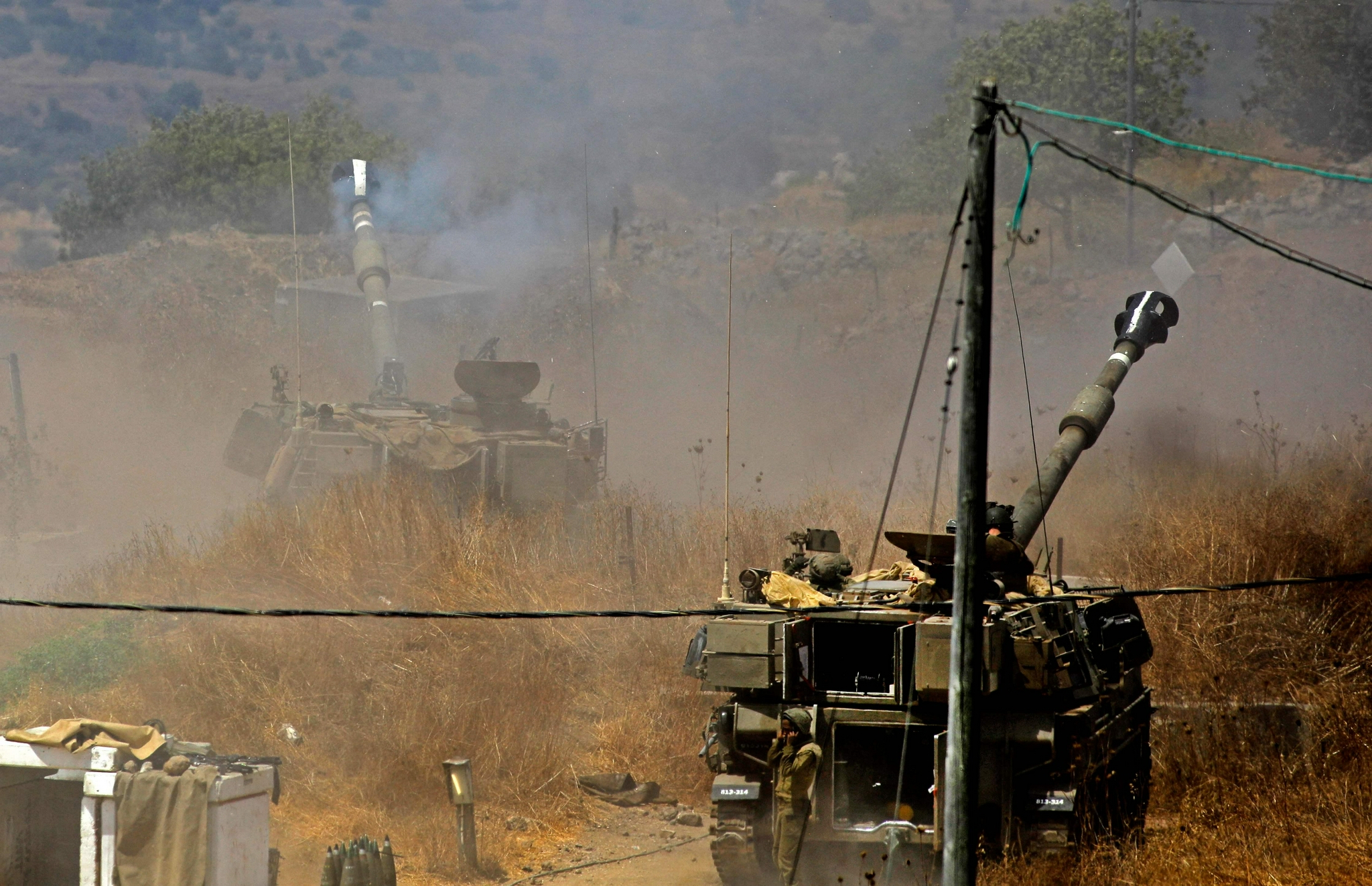 8月4日,在以色列谢莫纳镇,一辆自行榴弹炮进入阵地.新华社/法新
