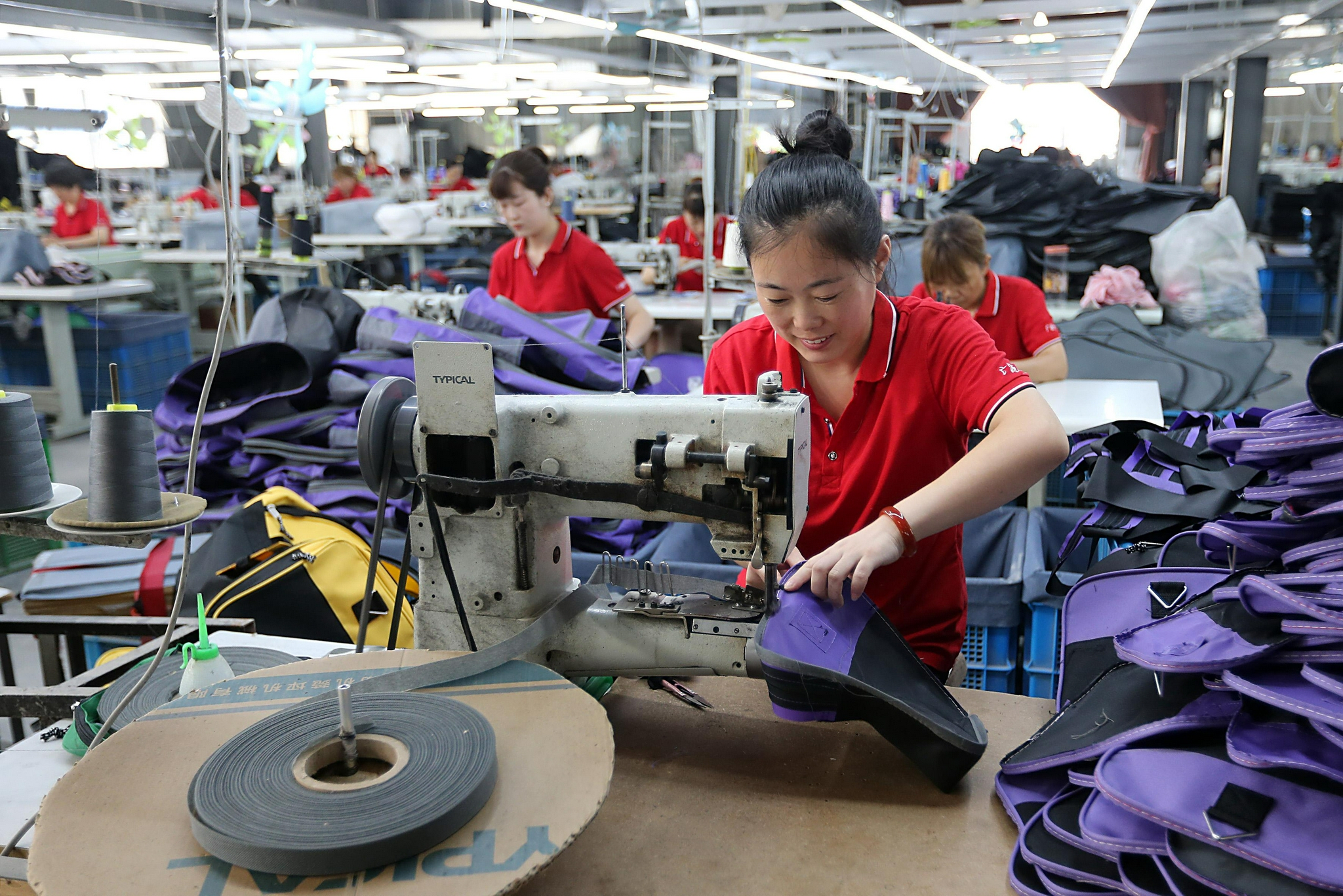 7月23日,务工人员在淮北市濉溪县刘桥镇一家编织袋生产企业车间作业.