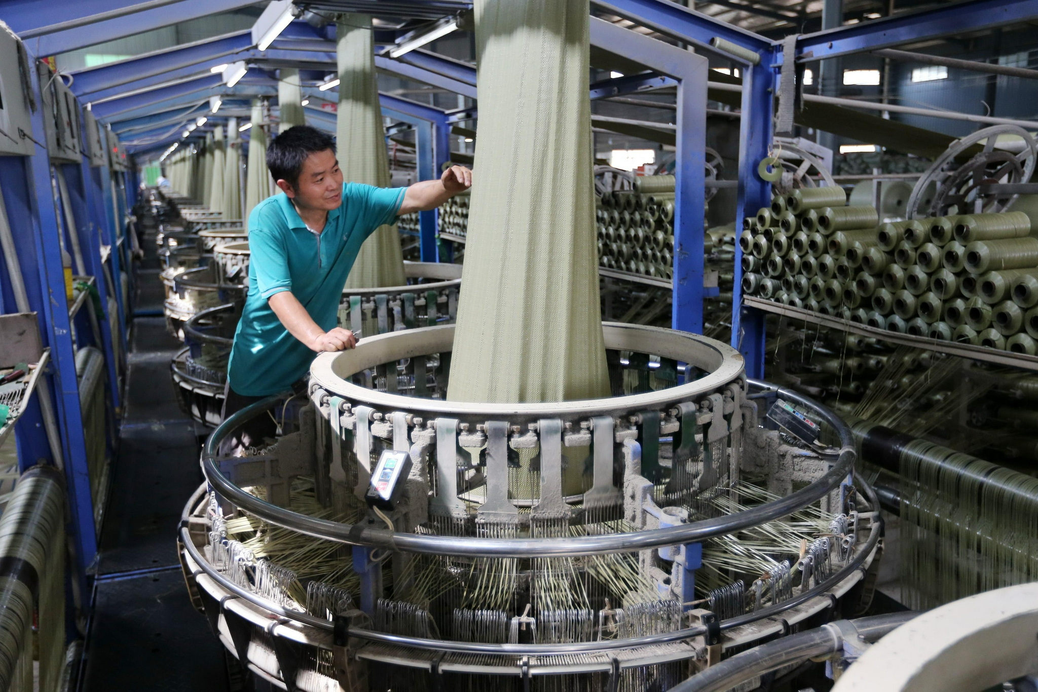 7月23日,务工人员在淮北市濉溪县刘桥镇一家饲料厂成品车间内装运饲料