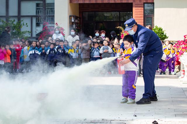 11月8日,在南京市雨花台区宏图上水幼儿园,小朋友在消防员的帮助下试