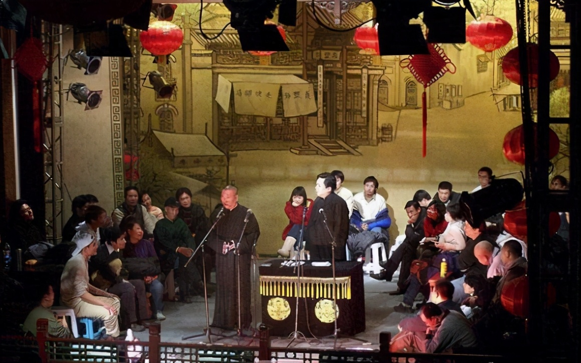 特别经典的照片出现了——桌子边上是郭德纲和于谦在说相声,桌子周围