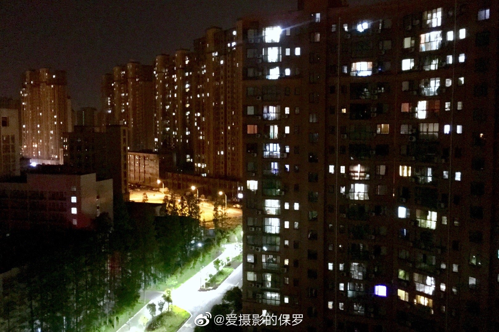 小区对面楼里透出灯光的窗越来越多了