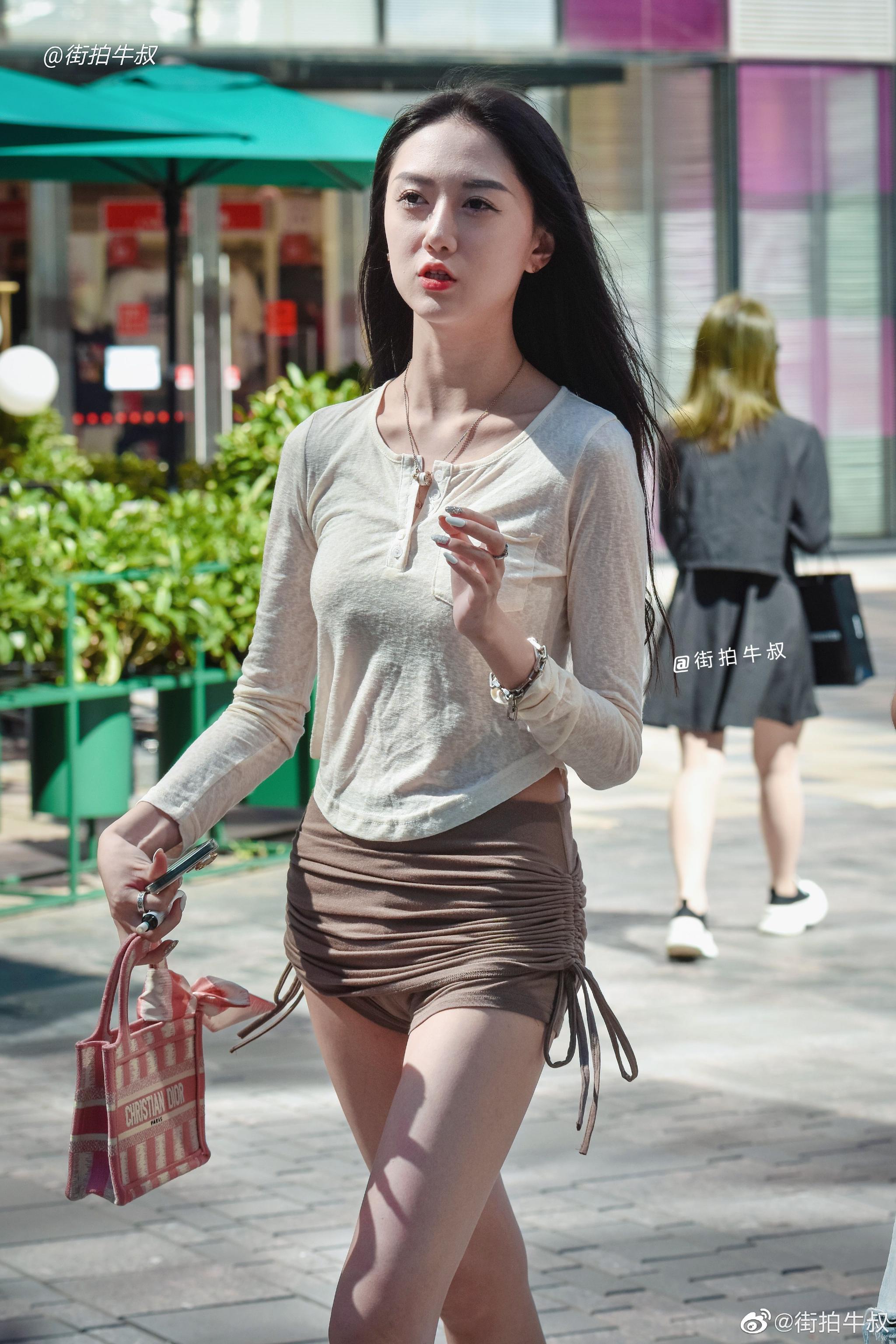 美女穿着时髦的紧身系带短裙出街