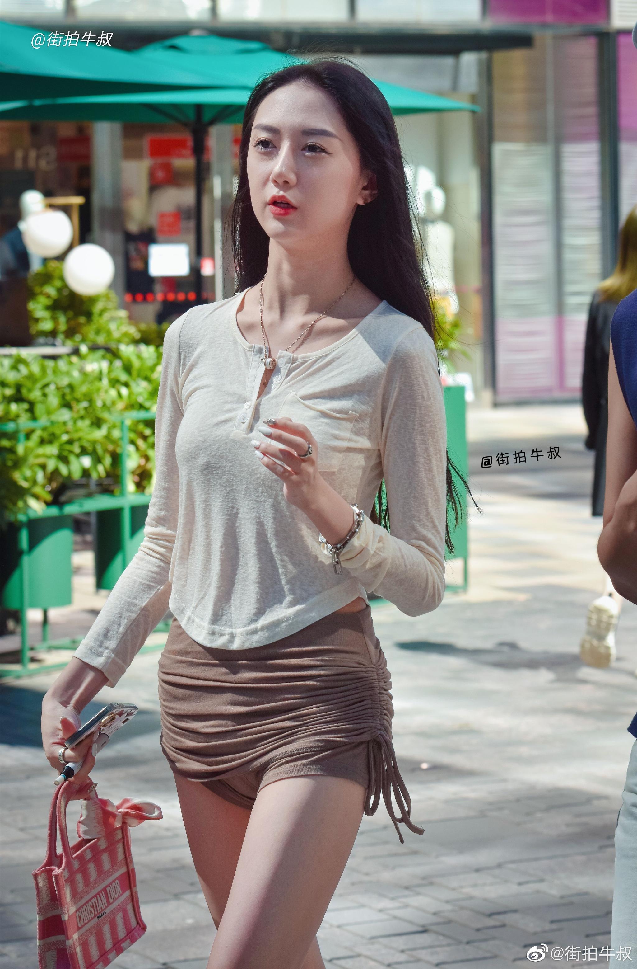 美女穿着时髦的紧身系带短裙出街