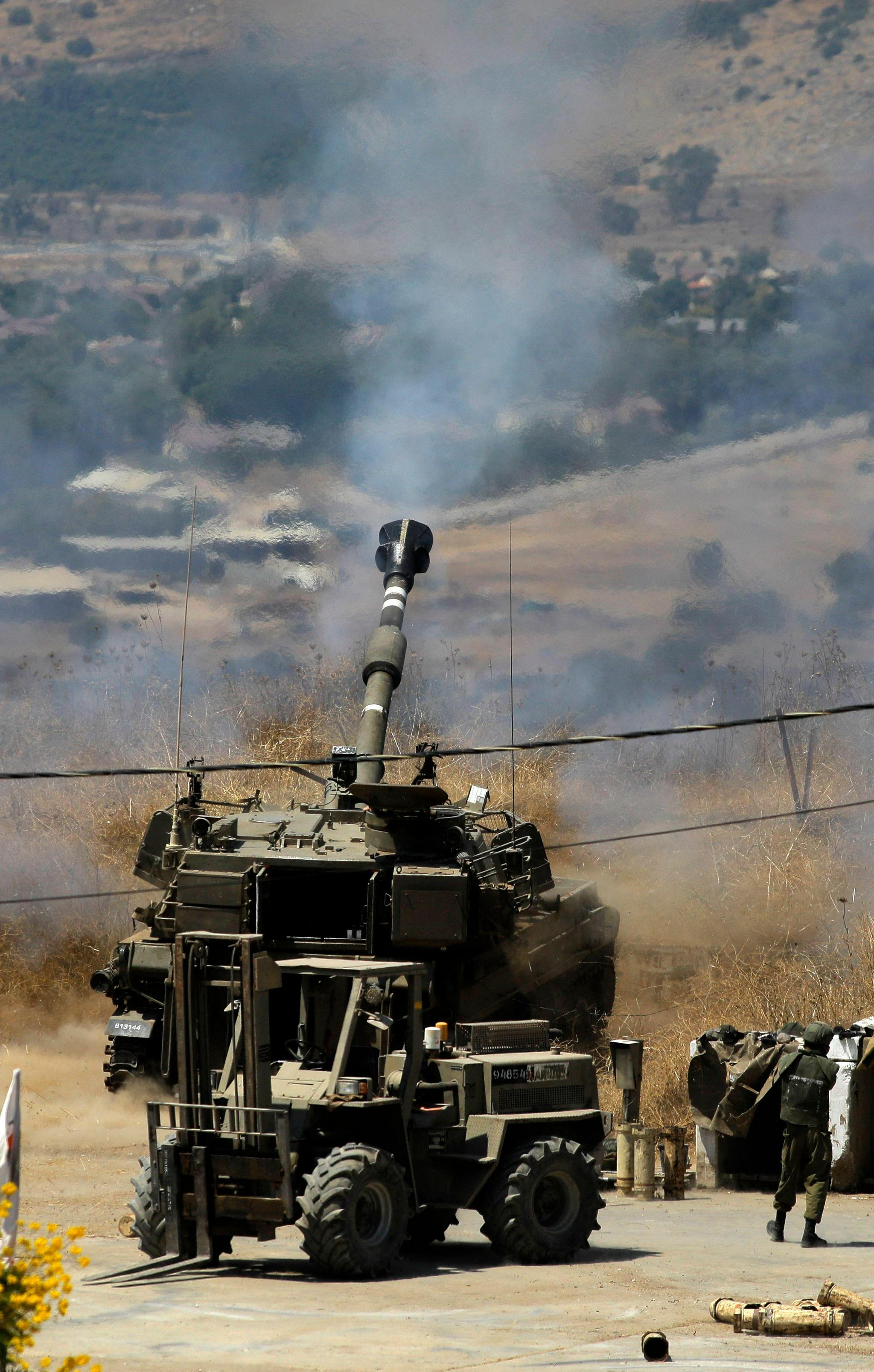 8月4日,在以色列谢莫纳镇,自行榴弹炮进入阵地.新华社/法新